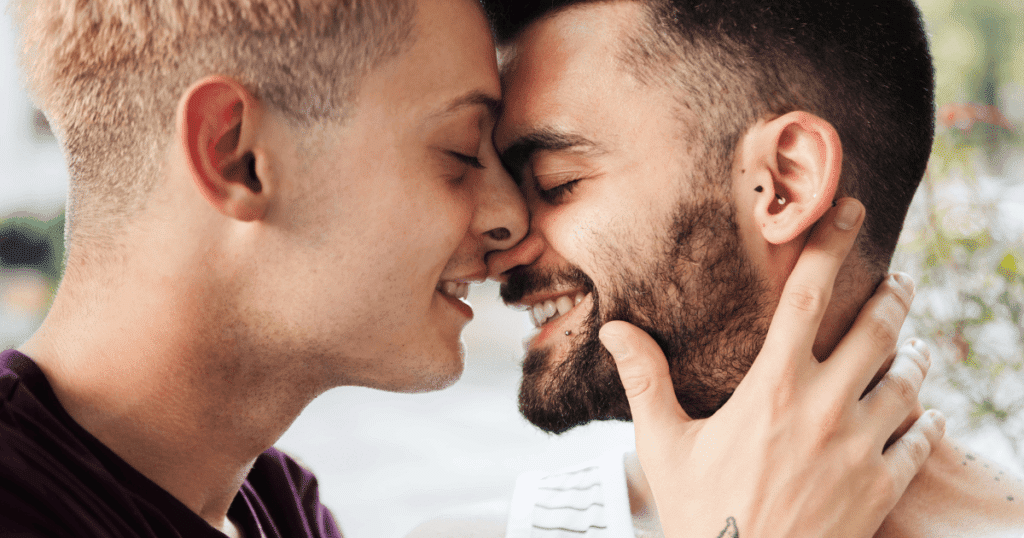 Primer plano de dos chicos sonriendo con sus frentes juntas, en un gesto de ternura y cariño.