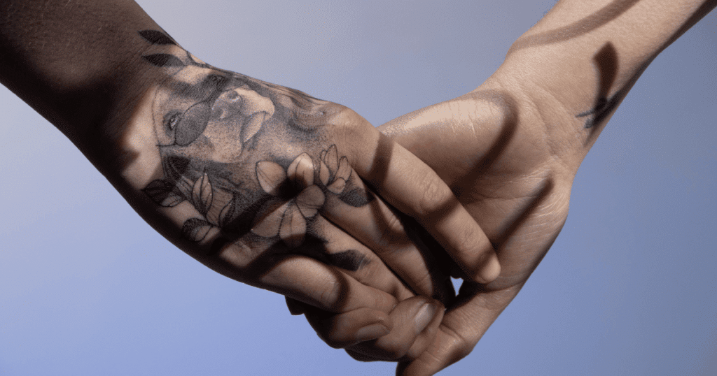 Primer plano de una mano cogiendo a otra con ternura, simbolizando apoyo, conexión y visibilidad.