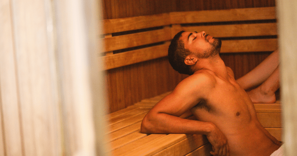 Un hombre joven y relajado, de cintura para arriba, en un ambiente de sauna, simbolizando un espacio de encuentro LGTBI+.