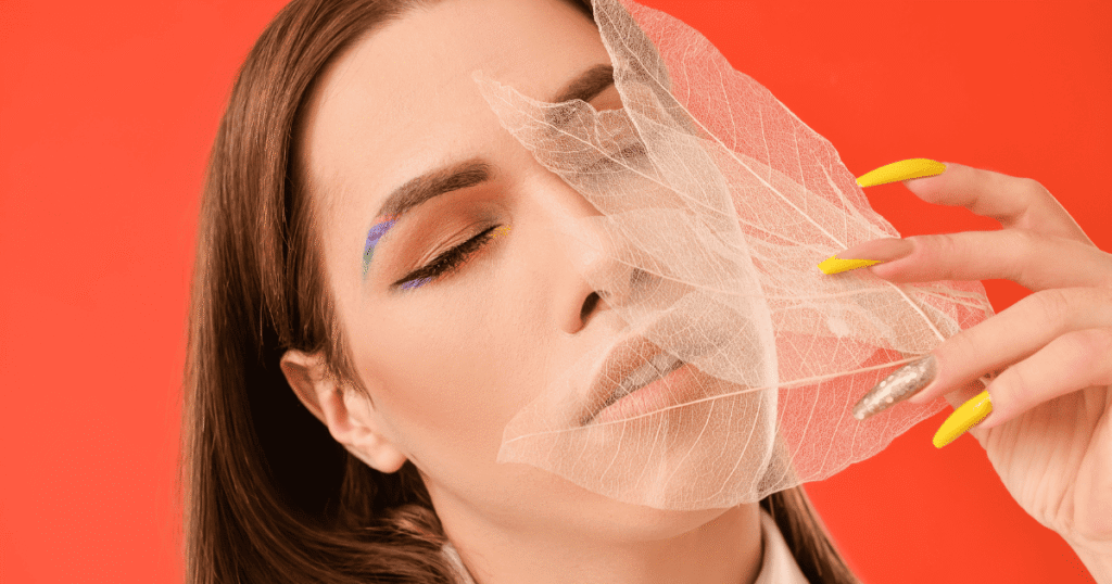 Primer plano de una mujer trans con un maquillaje elegante y expresión serena. Representa la visibilidad y la autoafirmación frente a la transfobia.
