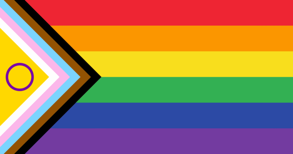 Bandera del Progreso LGTBIQA+ ondeando, con franjas de colores arcoíris, trans y las franjas negra y marrón.