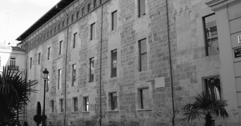 Fachada del edificio de Les Corts Valencianes en blanco y negro, simbolizando el retroceso en derechos LGTBI.