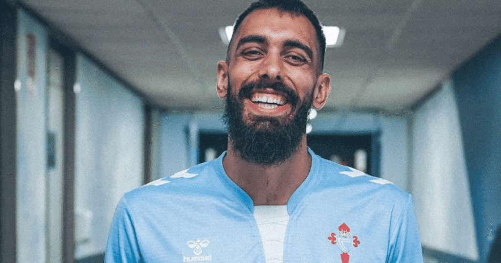 Borja Iglesias sonriendo con la camiseta del Celta de Vigo en el vestuario, ejemplo de aliado LGTBI+ en el fútbol.